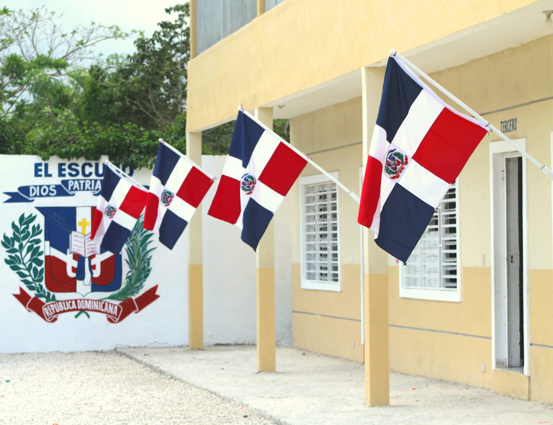 Fachada del Centro Educativo Rodney Henrikson con banderas dominicanas