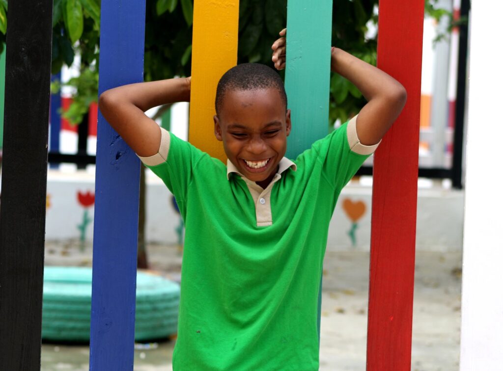 Estudiante sonriendo frente a la verja de colores